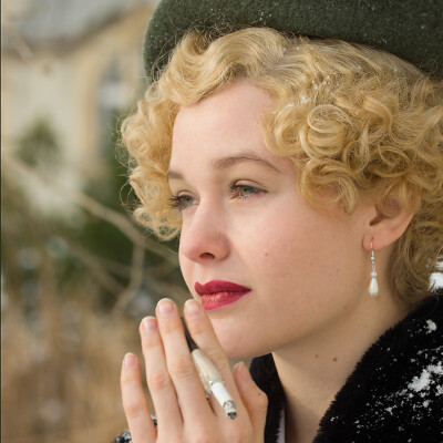 "Captivating elegance captured in the essence of the 1930s. π©β¨ Lena D. channels timeless sophistication with a touch of modern flair, styled and photographed by Anett Alexandra Bulano. #VintageStyle #MarleneInspired" "Half-close portrait of Lena D. in vintage-inspired attire against a black background, wearing a green barrett hat and brown Marlene pants. Styled and photographed by Anett Alexandra Bulano."